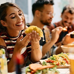 Woman smiling while eating lunch with friends at restaurant