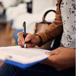 Woman filling out dental insurance form in lobby