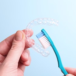 Patient cleaning clear aligner with toothbrush