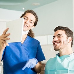 Dentist showing patient image on tablet