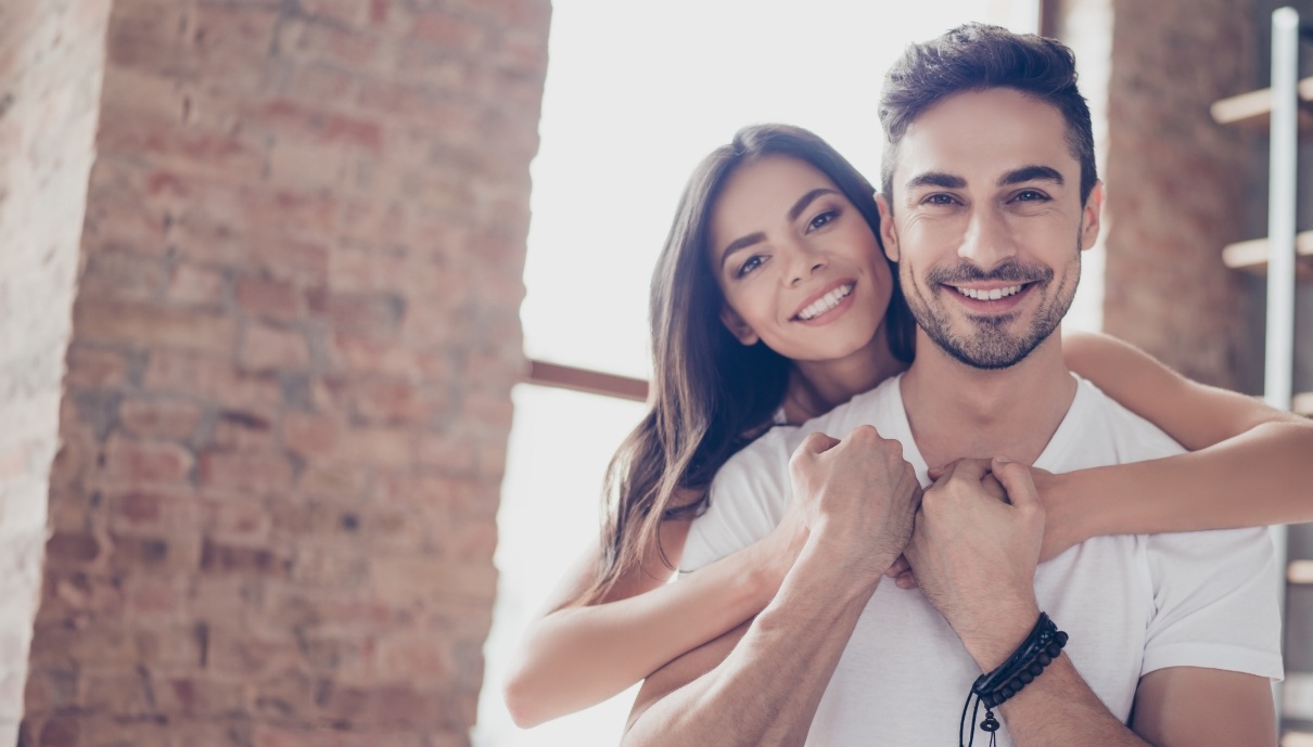 Man and woman smiling after restorative dentistry