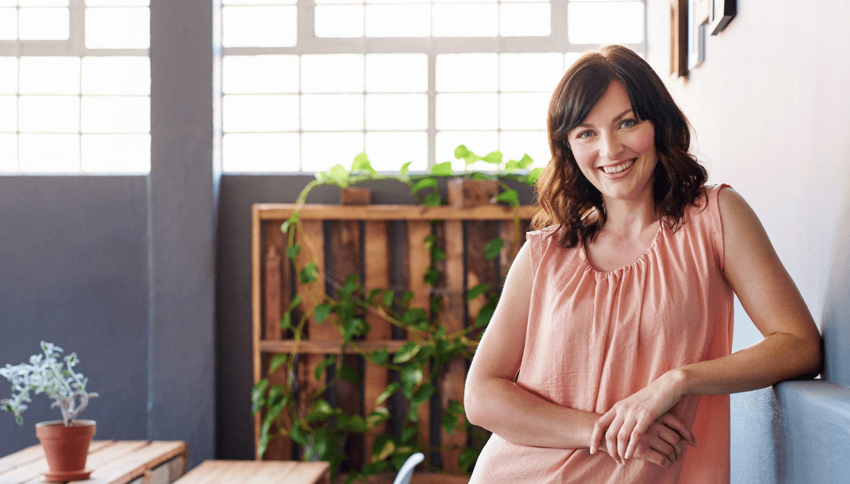 Woman smiling leaning on wall