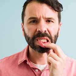 man pointing to inflamed gums 