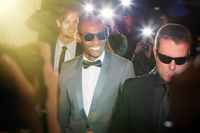 A smiling celebrity wearing sunglasses